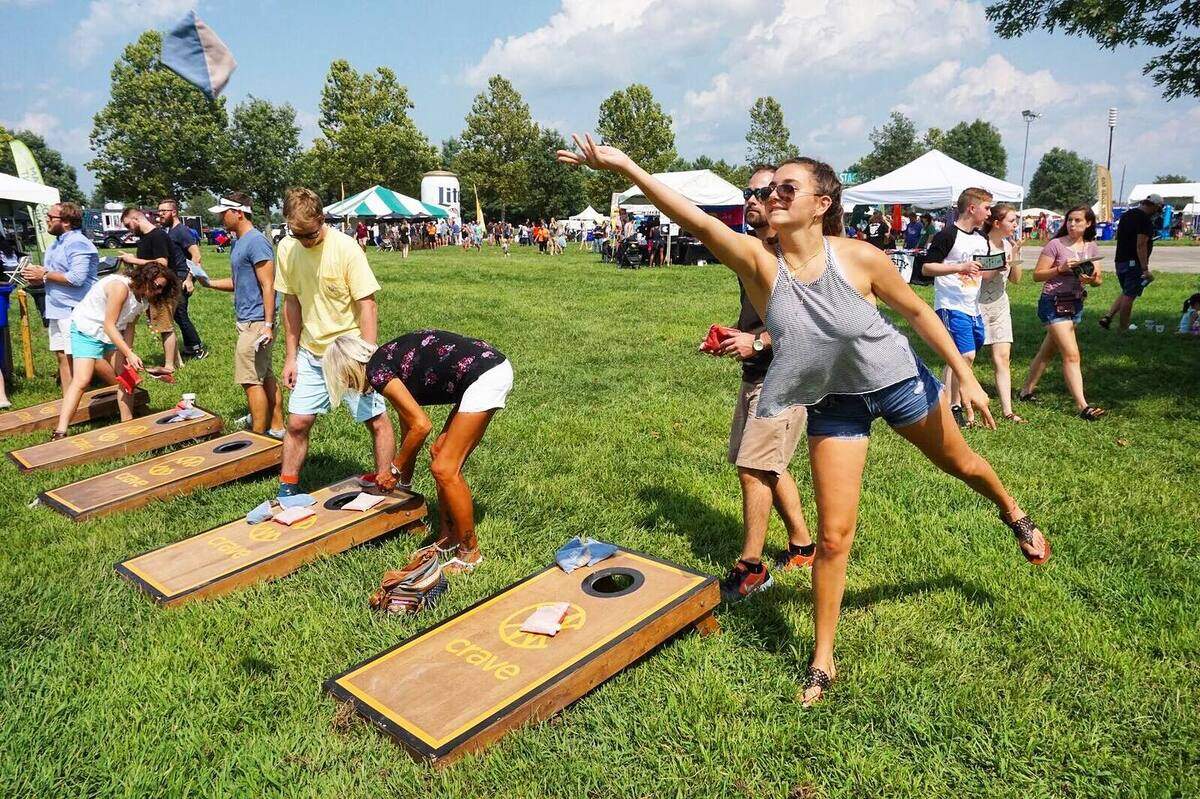 Festival-goers playing cornhole on Crave-branded boards at Gatton Park