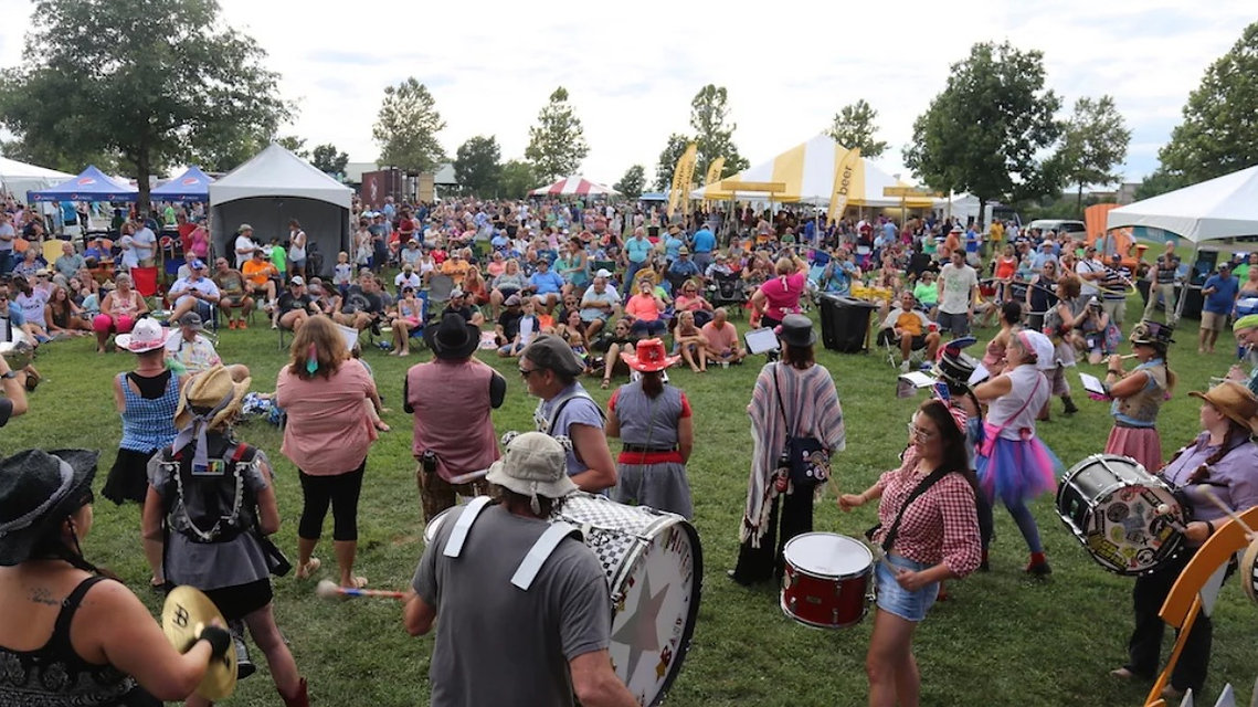 A marching band drum line performing for a crowd at the Crave festival