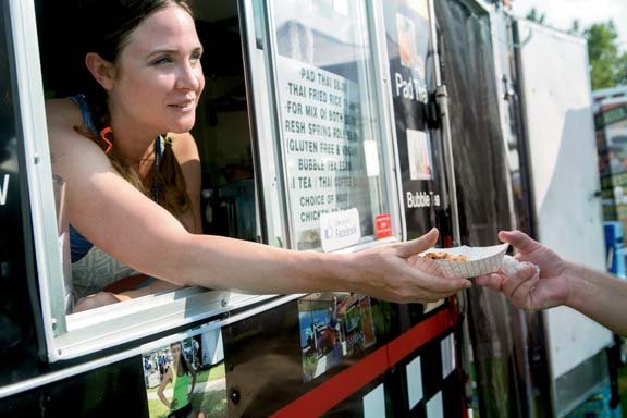 A vendor handing food from a truck window at the Crave festival