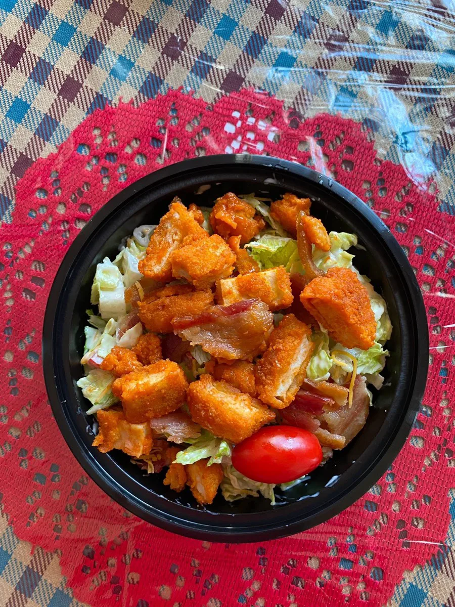 A homestyle fried chicken bowl on a red doily from Salt Mine Cafe.